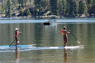 Photo of two people and their dog on paddleboards at Pinecrest Lake, CA